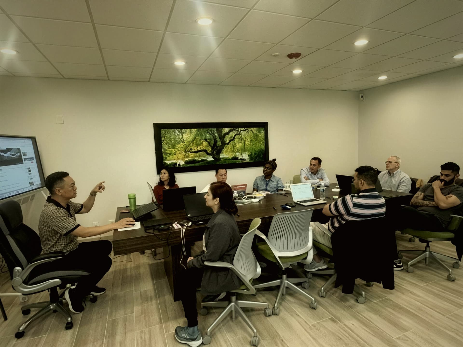 Dr. TJ Ahn teaching members around the boardroom table at a live in-person session